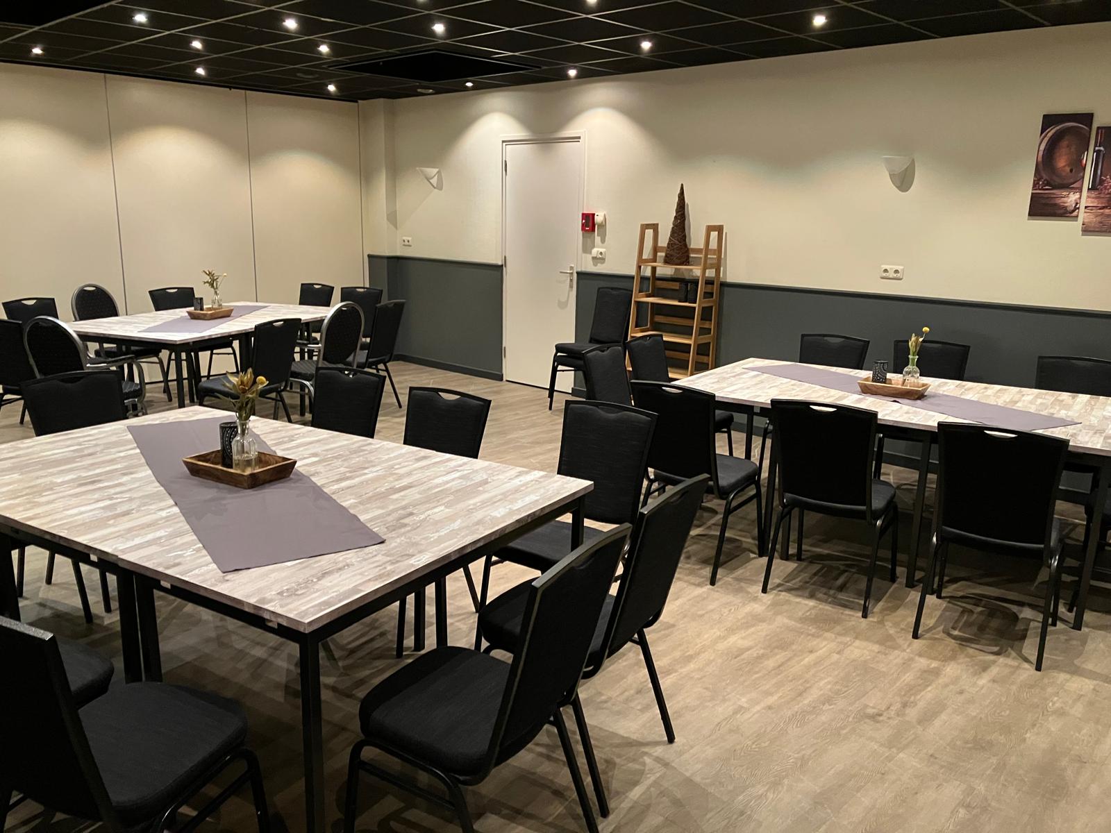 Zaal Oost in Dorpshuis Hierden: lichte ruimte met tafels en stoelen voor een vergadering.